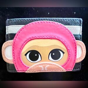 A Striped Kate Spade New York Credit  Card Case with a Colorful Monkey Graphic.